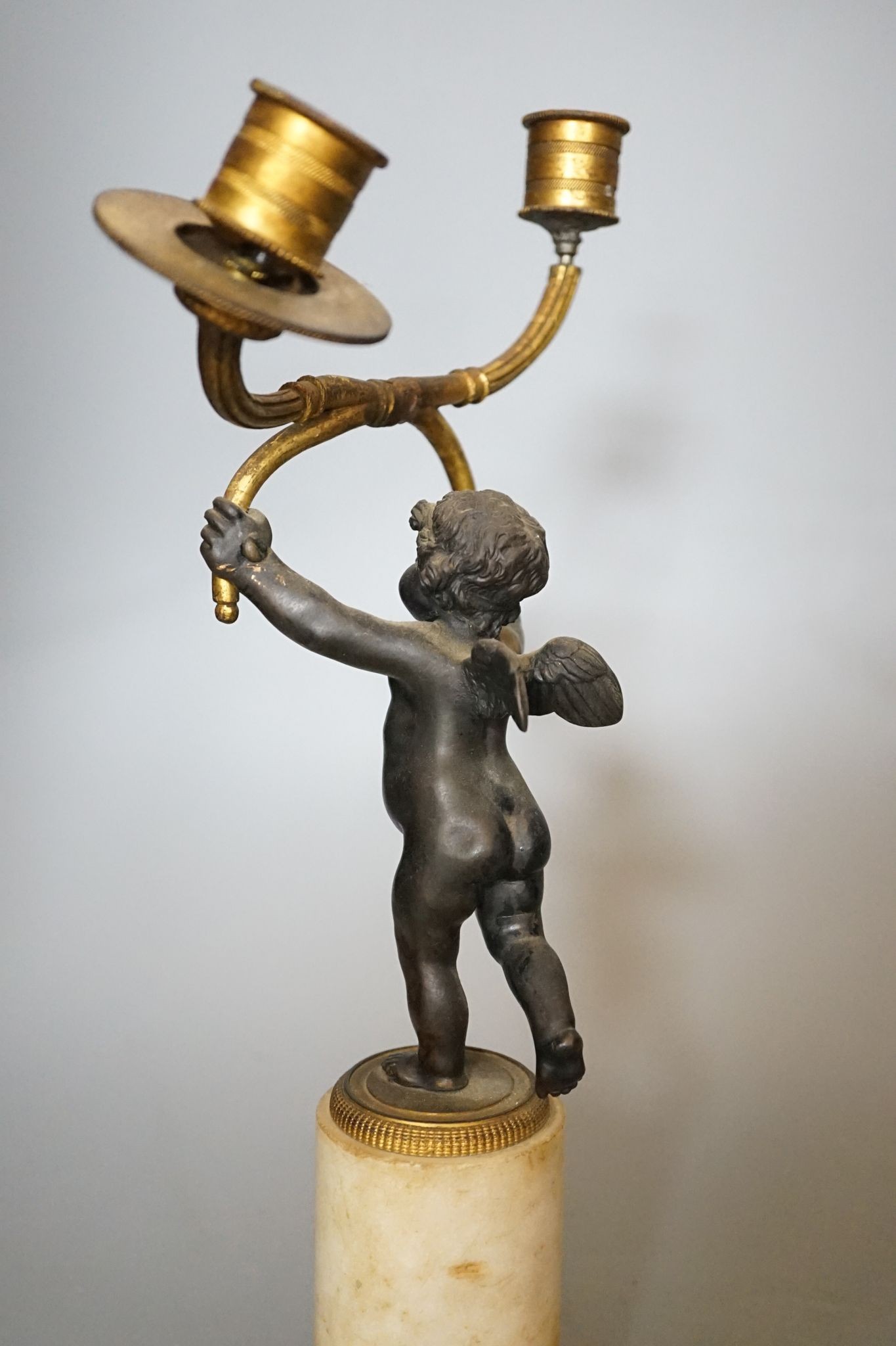 A pair of 19th century bronze and ormolu cherub candelabra, on alabaster plinths, 33cm